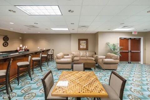10811 Front Beach Rd Unit 2304, Panama City Beach, FL 32407 - carpeted dining room with a bar and a paneled ceiling