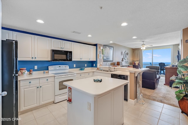 10811 Front Beach Rd Unit 2304, Panama City Beach, FL 32407 - kitchen with black appliances, open floor plan, light countertops, light tile patterned flooring, and a peninsula