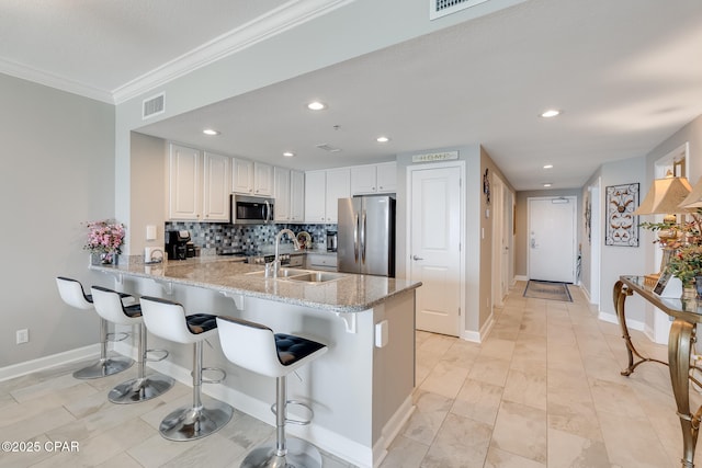 10713 Front Beach Rd Unit 904, Panama City Beach, FL 32407 - kitchen with stainless steel appliances, a peninsula, crown molding, light stone countertops, and a breakfast bar area