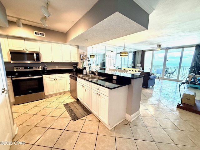 14701 Front Beach Rd Unit 536, Panama City Beach, FL 32413 - kitchen with appliances with stainless steel finishes, light tile patterned floors, open floor plan, a peninsula, and dark countertops