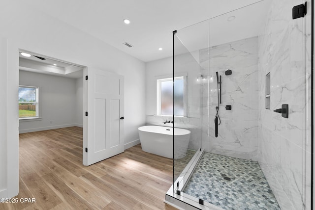 1306 E 26th St, Lynn Haven, FL 32444 - bathroom featuring wood finished floors, a marble finish shower, a freestanding bath, and recessed lighting