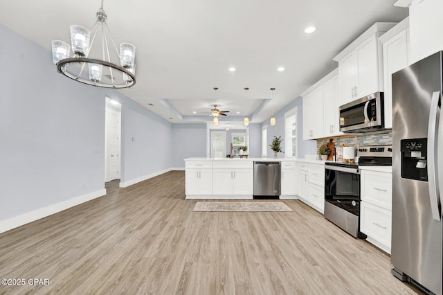 112 Christopher Dr Unit B, Panama City Beach, FL 32413 - kitchen with stainless steel appliances, a raised ceiling, a peninsula, recessed lighting, and open floor plan
