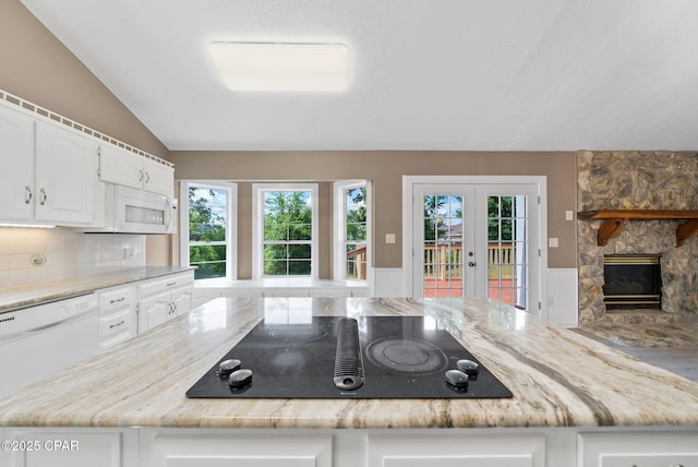 1601 Loblolly Ln, Lynn Haven, FL 32444 - kitchen with white appliances, french doors, white cabinets, light stone counters, and a wainscoted wall