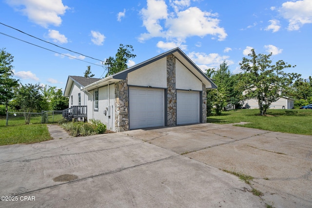 1601 Loblolly Ln, Lynn Haven, FL 32444 - view of home's exterior with stone siding, stucco siding, a garage, and driveway
