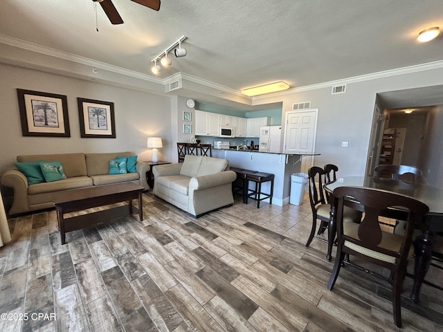 16819 Front Beach Rd Unit 107, Panama City Beach, FL 32413 - living area with track lighting, crown molding, ceiling fan, wood finished floors, and a textured ceiling