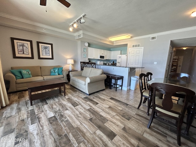 16819 Front Beach Rd Unit 107, Panama City Beach, FL 32413 - living area featuring wood finished floors, crown molding, a ceiling fan, track lighting, and a textured ceiling
