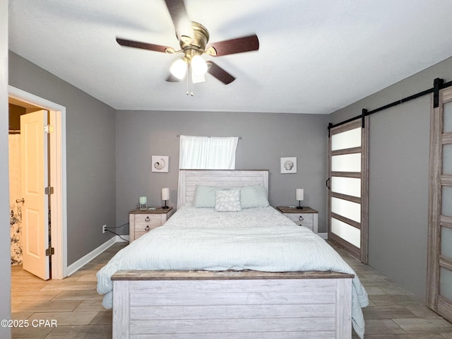2816 N Panama Ave Unit A & B, Panama City, FL 32405 - bedroom with a barn door, light wood-style floors, and a ceiling fan