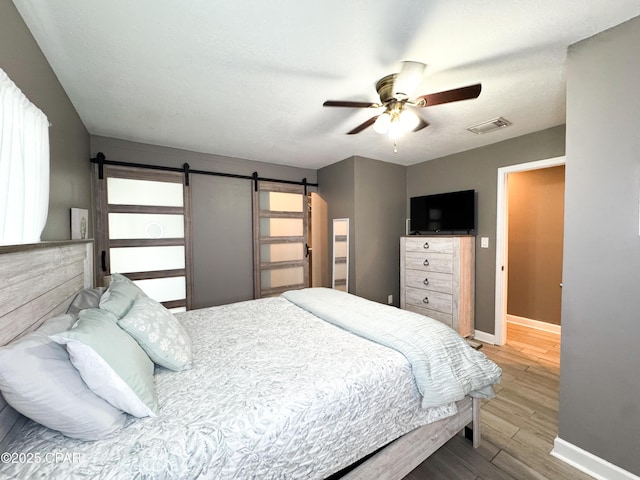 2816 N Panama Ave Unit A & B, Panama City, FL 32405 - bedroom with wood finished floors, a barn door, and a ceiling fan