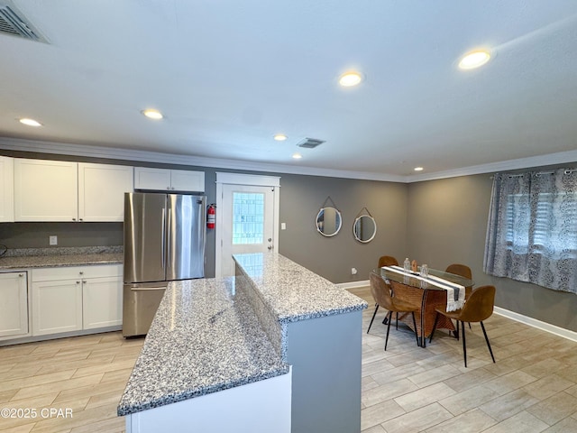 2816 N Panama Ave Unit A & B, Panama City, FL 32405 - kitchen featuring freestanding refrigerator, crown molding, light stone countertops, recessed lighting, and white cabinets