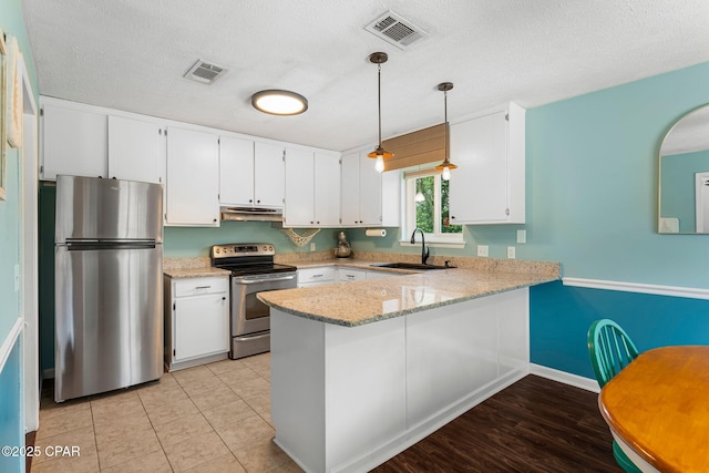 4004 E 7th Cir, Panama City, FL 32404 - kitchen featuring stainless steel appliances, under cabinet range hood, a peninsula, light stone countertops, and white cabinets