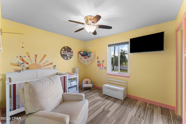 4004 E 7th Cir, Panama City, FL 32404 - bedroom featuring wood finished floors, a nursery area, ceiling fan, and a textured ceiling