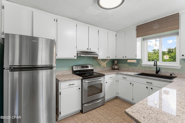 4004 E 7th Cir, Panama City, FL 32404 - kitchen featuring stainless steel appliances, under cabinet range hood, a textured ceiling, light countertops, and light tile patterned flooring