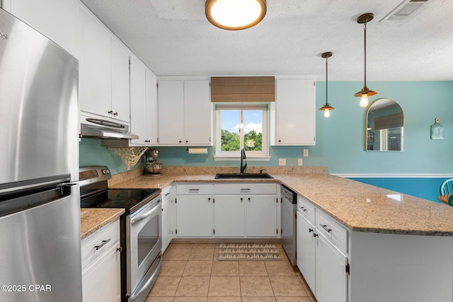 4004 E 7th Cir, Panama City, FL 32404 - kitchen with stainless steel appliances, under cabinet range hood, a peninsula, a textured ceiling, and white cabinets