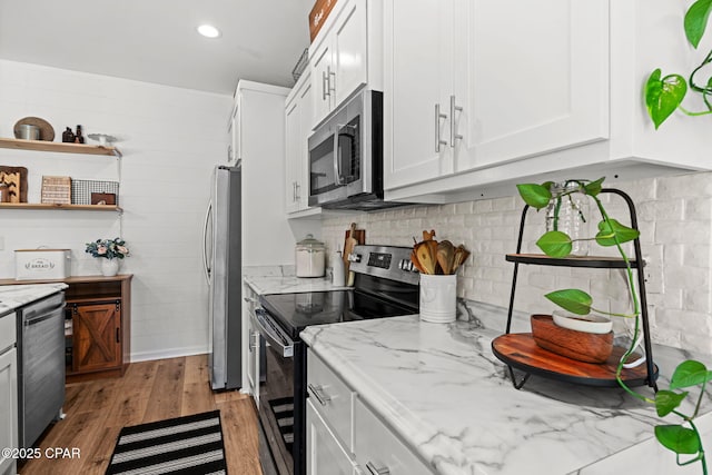 406 Raven Ln, Panama City, FL 32404 - kitchen with appliances with stainless steel finishes, light stone counters, white cabinetry, light wood-style floors, and recessed lighting