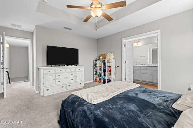 406 Raven Ln, Panama City, FL 32404 - carpeted bedroom featuring a raised ceiling, ensuite bath, and a ceiling fan