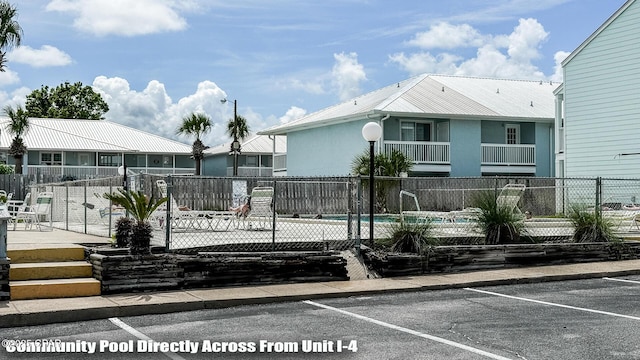 17670 Front Beach Rd Unit I4, Panama City Beach, FL 32413 - view of front of home with uncovered parking, a metal roof, a community pool, and stucco siding