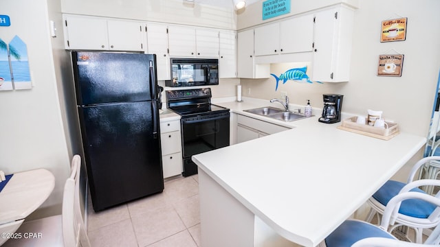 17670 Front Beach Rd Unit I4, Panama City Beach, FL 32413 - kitchen with black appliances, a peninsula, white cabinetry, light countertops, and a breakfast bar