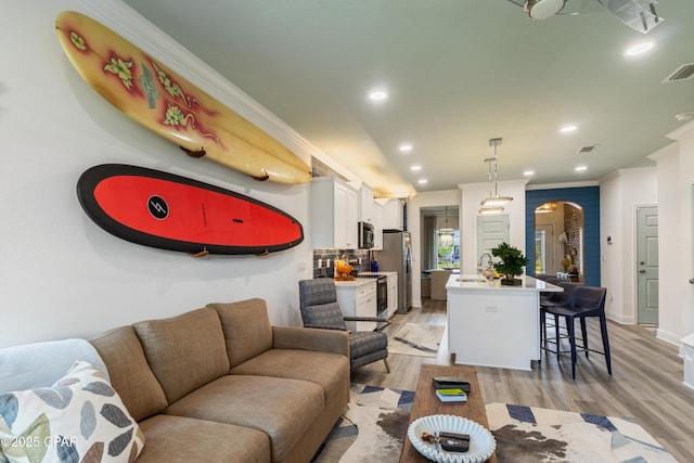 21818 Kelly Pines Pl, Panama City Beach, FL 32413 - living area with ornamental molding, arched walkways, light wood-style floors, and recessed lighting