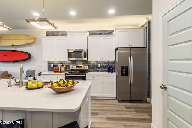 21818 Kelly Pines Pl, Panama City Beach, FL 32413 - kitchen featuring appliances with stainless steel finishes, light wood finished floors, white cabinetry, backsplash, and light countertops