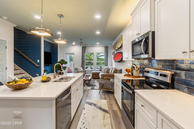 21818 Kelly Pines Pl, Panama City Beach, FL 32413 - kitchen featuring stainless steel appliances, open floor plan, wood finished floors, white cabinetry, and recessed lighting