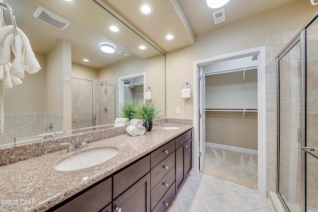 8700 Front Beach Rd Unit 7207, Panama City Beach, FL 32407 - bathroom with a spacious closet, double vanity, a stall shower, tile patterned floors, and recessed lighting
