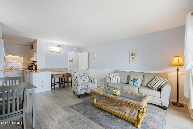 8743 Thomas Dr Unit 928, Panama City Beach, FL 32408 - living area with light wood-type flooring and a wainscoted wall