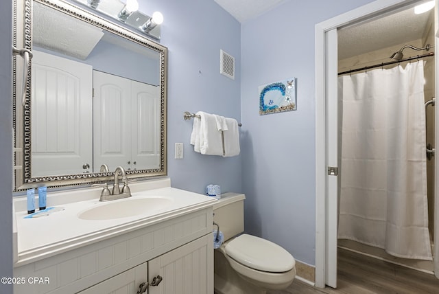 8743 Thomas Dr Unit 928, Panama City Beach, FL 32408 - bathroom with vanity, wood finished floors, a textured ceiling, and curtained shower