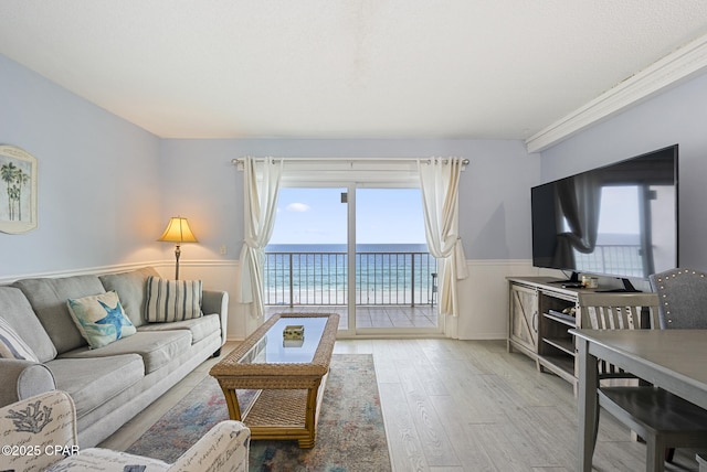 8743 Thomas Dr Unit 928, Panama City Beach, FL 32408 - living area with healthy amount of natural light, wood finished floors, and a wainscoted wall