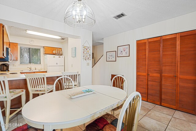 17620 Front Beach Rd Unit 4U, Panama City Beach, FL 32413 - dining area with light tile patterned flooring, a chandelier, and a textured ceiling