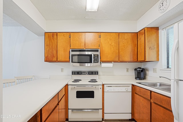 17620 Front Beach Rd Unit 4U, Panama City Beach, FL 32413 - kitchen with white appliances, light countertops, a textured ceiling, and brown cabinetry