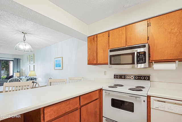 17620 Front Beach Rd Unit 4U, Panama City Beach, FL 32413 - kitchen with white appliances, a textured ceiling, light countertops, open floor plan, and decorative light fixtures