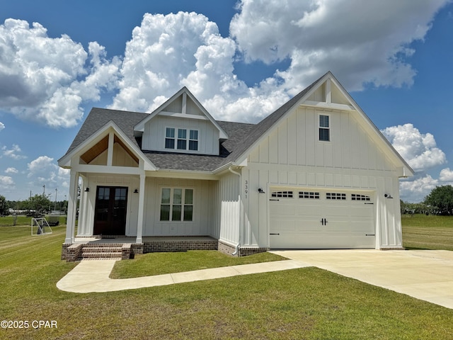 3391 Grey Oak Way, Marianna, FL 32446 - view of front facade featuring roof with shingles, driveway, board and batten siding, a front lawn, and a garage