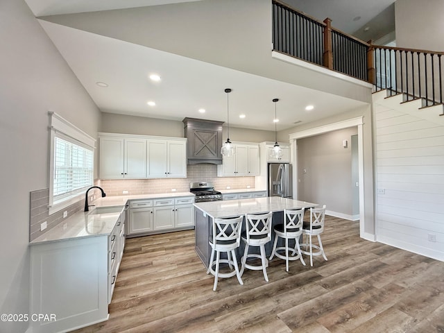 3391 Grey Oak Way, Marianna, FL 32446 - kitchen with appliances with stainless steel finishes, a center island, light wood-style floors, a kitchen bar, and tasteful backsplash