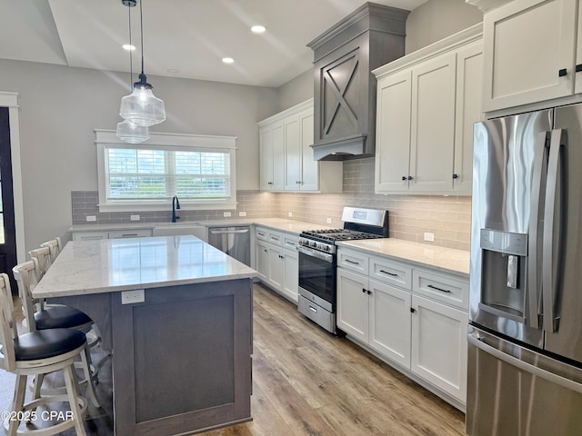 3391 Grey Oak Way, Marianna, FL 32446 - kitchen featuring stainless steel appliances, a kitchen bar, a kitchen island, light stone countertops, and white cabinets