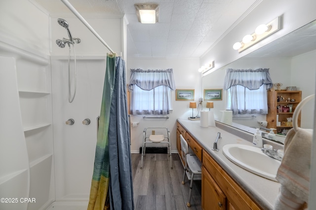 1016 Morgan Ave, Chattahoochee, FL 32324 - bathroom with healthy amount of natural light, a shower with shower curtain, vanity, wood finished floors, and crown molding