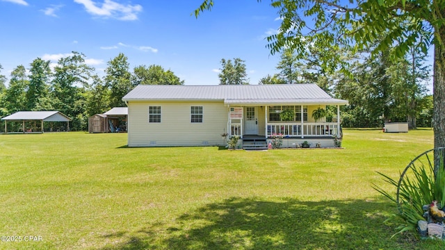 3483 Kynesville Rd, Marianna, FL 32448 - view of front of home with a porch, a front lawn, a storage shed, and a metal roof