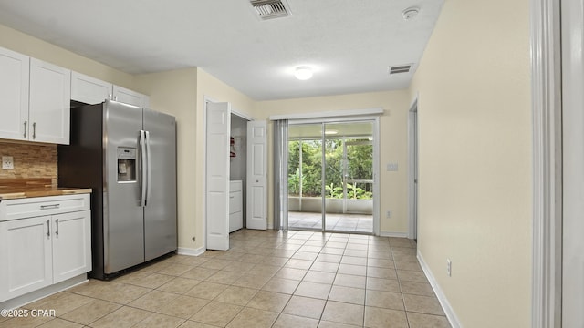 3023 Meadow St, Lynn Haven, FL 32444 - kitchen with stainless steel fridge with ice dispenser, white cabinetry, light tile patterned floors, and decorative backsplash