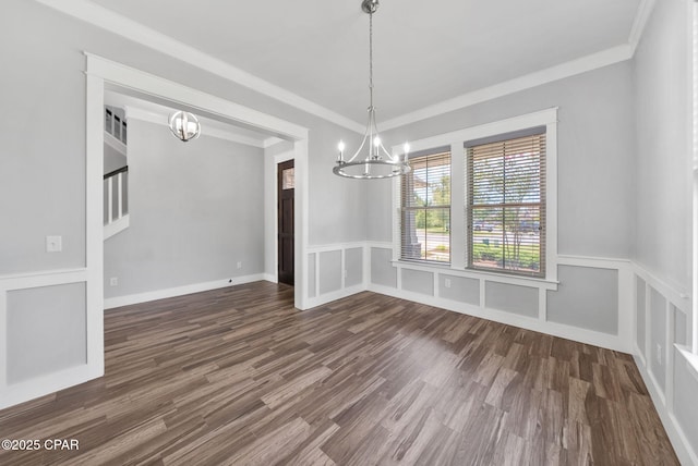 3033 Osprey Cir, Panama City, FL 32405 - unfurnished dining area featuring a chandelier, crown molding, dark wood-style floors, wainscoting, and a decorative wall