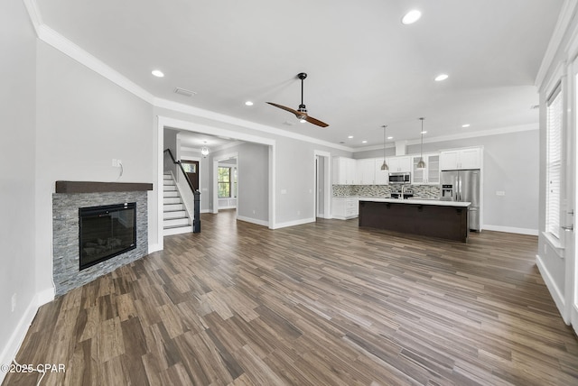 3033 Osprey Cir, Panama City, FL 32405 - unfurnished living room featuring recessed lighting, a fireplace, a ceiling fan, ornamental molding, and dark wood-type flooring