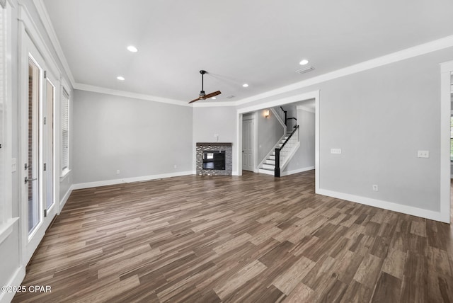 3033 Osprey Cir, Panama City, FL 32405 - unfurnished living room featuring a ceiling fan, crown molding, a glass covered fireplace, wood finished floors, and recessed lighting