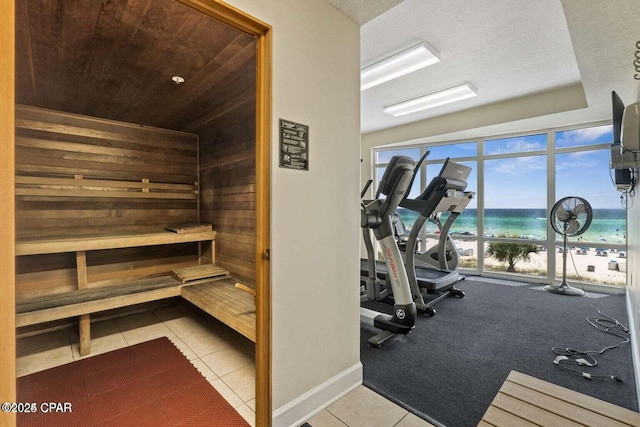 10625 Front Beach Rd Unit 1902, Panama City Beach, FL 32407 - gym featuring a sauna / steam room, a water view, tile patterned flooring, wooden ceiling, and wood walls
