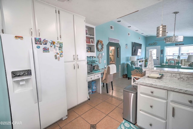 101 Gulf Loop, Panama City Beach, FL 32408 - kitchen featuring white refrigerator with ice dispenser, white cabinetry, light countertops, light tile patterned floors, and a textured ceiling