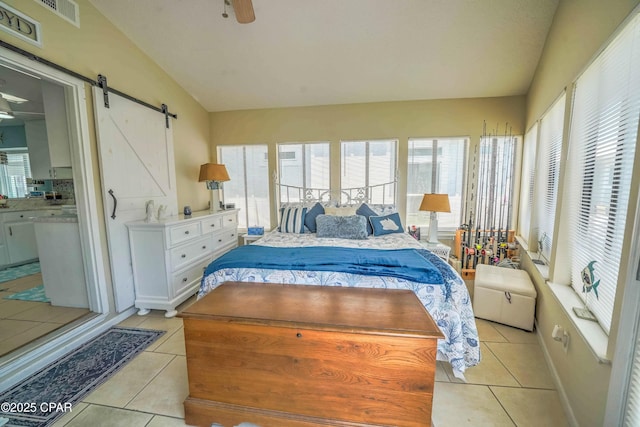 101 Gulf Loop, Panama City Beach, FL 32408 - bedroom with light tile patterned flooring, a barn door, ensuite bathroom, and a ceiling fan