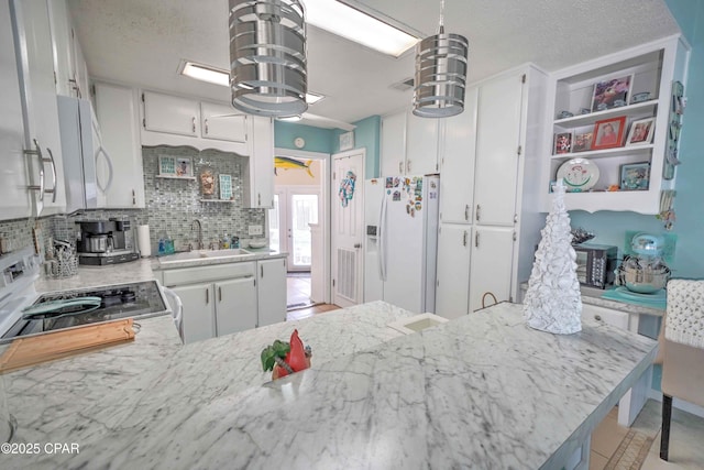 101 Gulf Loop, Panama City Beach, FL 32408 - kitchen with white appliances, decorative backsplash, white cabinets, and a textured ceiling