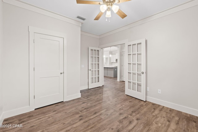 902 Captain Way, Panama City, FL 32404 - unfurnished bedroom with french doors, crown molding, wood finished floors, and ceiling fan