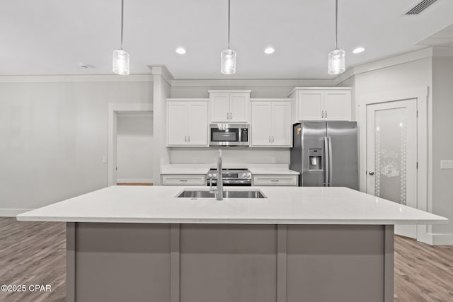 902 Captain Way, Panama City, FL 32404 - kitchen featuring appliances with stainless steel finishes, an island with sink, white cabinets, light wood finished floors, and recessed lighting