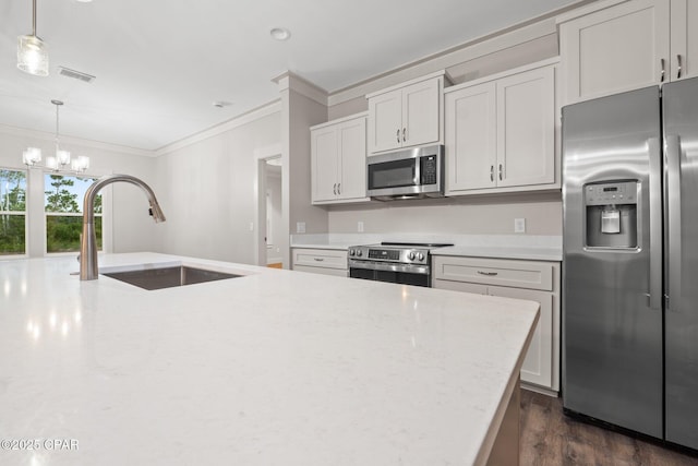 902 Captain Way, Panama City, FL 32404 - kitchen with stainless steel appliances, ornamental molding, a chandelier, dark wood finished floors, and hanging light fixtures