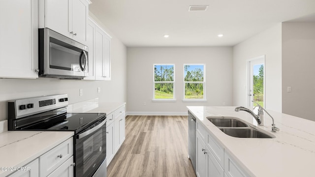4866 Windrow Way, Panama City, FL 32404 - kitchen with appliances with stainless steel finishes, light wood-style flooring, white cabinetry, recessed lighting, and light stone countertops