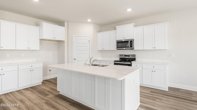 4866 Windrow Way, Panama City, FL 32404 - kitchen featuring appliances with stainless steel finishes, light wood-type flooring, a center island with sink, white cabinetry, and recessed lighting
