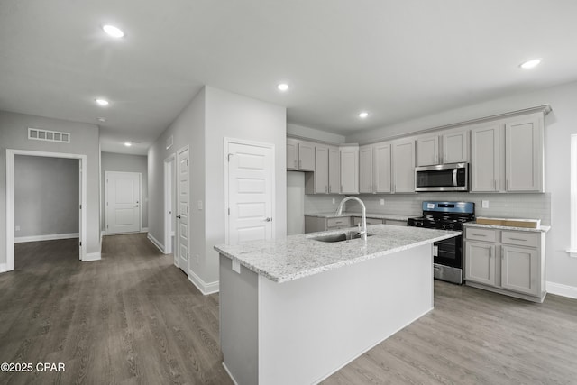 237 Mosaic Dr Unit 42, Port St Joe, FL 32456 - kitchen featuring stainless steel appliances, wood finished floors, light stone countertops, backsplash, and recessed lighting